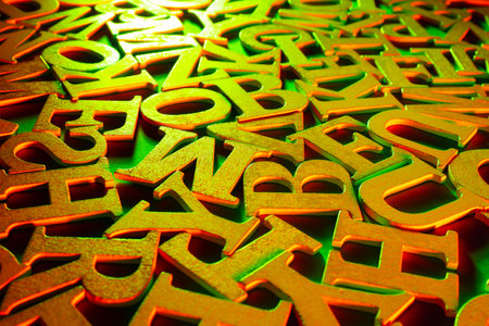 Golden alphabet letters. Volumetric gilded letters. Alphabet is in a chaotic state. Letters as a symbol of reading. Reading English literature. Reading training. Concept - writing and selling booksの写真素材