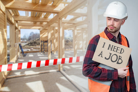 I need a job. Tuilder lost his job. Concept - construction is closed due to bankruptcy. Tape symbolizes termination of construction. White-red ribbon closes passage. Holds a paper with inscription.の写真素材