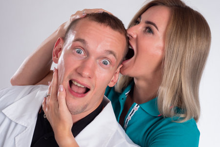 Woman bites the man head. Man and a woman are having fun together. Concept is lovers. Girl is having fun with the guy. She hugs and bites the guy. Lovers couple posing together.の写真素材