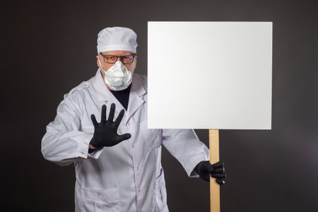 Doctor is trying to stop you. White banner as a symbol of protest. Doctor with a banner warns of a threat. Concept - doctor stops from wrong actions. Medic opposes health care reforms. Respiratorの写真素材