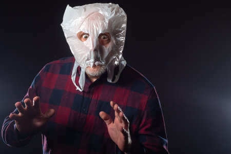 Adult man with a package on his head. Human put on a bag with slits for the eyes. Man in a...