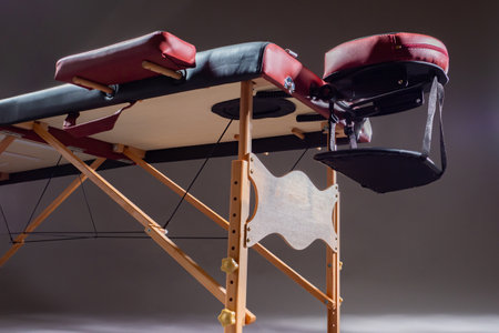 Professional massage table bottom view. Massage room equipment. Workplace of the masseur. Massage table with headrest and armrests.の写真素材