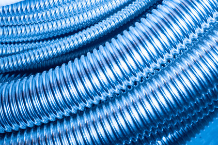 Flexible stainless steel pipes. Pipes for protecting electrical wires. Background made of corrugated bushings for electrical cables. Bushing for laying wires.の写真素材