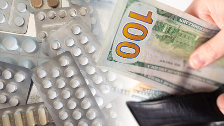 Pills next to dollars. Many packages of drugs. Concept - cost of the medicine. Health care costs. Concept - purchase of antiviral drugs. The presentation of drugs during a fever. Wallet with moneyの写真素材