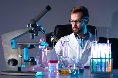 Virologist works in a laboratory. Laboratory technician is working on a vaccine. Lots of tubes next to virologist. Concept - development of vaccine against virus. Creation of a cure for pindaemia.の写真素材