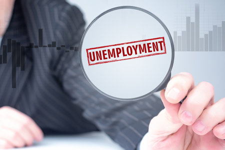 A man studies the labor market. Unemployment in the labor market. A study of employment and unemployment. The word Unemployment through a magnifying glass. Mass reduction of the personnel.の写真素材