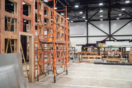 Preparation of the premises for the exhibition. Installation of partitions in the exhibition hall. Scaffolding next to a wooden frame in the exhibition complex. Installation of advertising structures.の写真素材