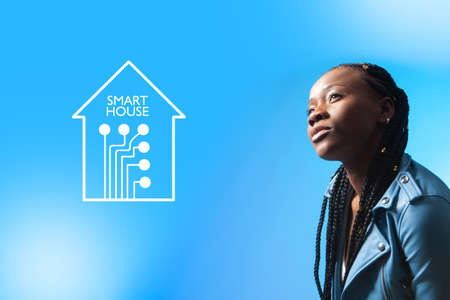 Dark-skinned girl dreams of a smart home. African-American woman is going to connect the cottage to the Smart Home system. Woman wants to use a home automation system. IOT and African-American model.の写真素材