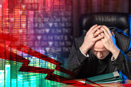 Business ruin. Problems in business. Bankruptcy of an entrepreneur. A man is stressed against the background of a falling chart. Ruin, bankruptcy. Losses of the company.の写真素材