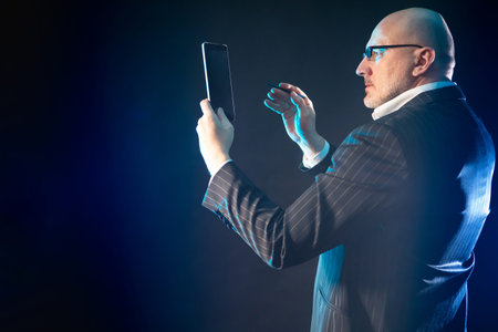 A man with a big phone in his hands. Concept - businessman takes a selfie. Adult man peers into a...