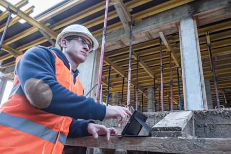 Builder. An architect works at a construction site. A guy with a tablet on the background of a...