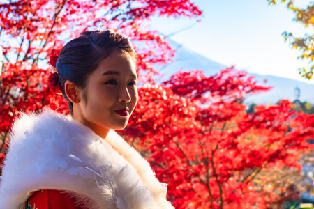 Japan. Geisha. Girl near japanese maple. Japanese girl on the background of red maple. A geisha is pausing on the background of Fuji. Woman next to japanese maple. Girl in Japanese Kimano. 11.14.2019のeditorial素材