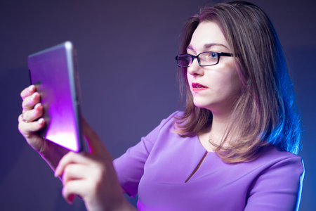 Girl with a tablet in her hands. Concept - businesswoman. A woman holds a tablet in front of her....