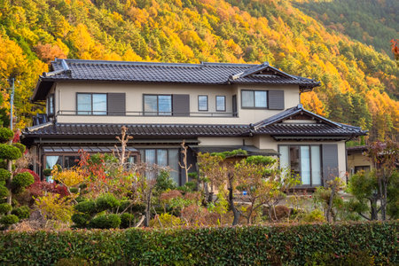 Japan. House in the city of Fujikawaguchiko. Hotel on shores of Lake Kawaguchiko. Cottage for tourists in a picturesque place. Japan in autumn day. House is surrounded by colorful trees. 11.15.2019のeditorial素材