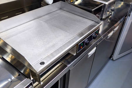Electric industrial frying pan. Frying surface in a restaurant. New restaurant equipment top view. Concept - sale of restaurant equipment. Industrial frying surface with smooth and ribbed surfaceの写真素材