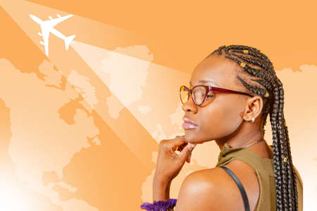 Dark-skinned girl student dreams of traveling. Traveler on background of world map. Concept - she thinks over route for trip. Orange map airplane. Girl wants to go on a tour trip. Woman travelerの写真素材