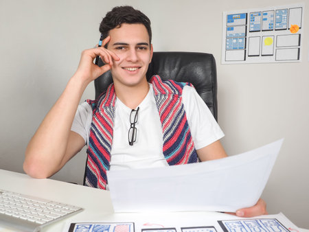 Apps developer looks in camera. Apps developer works in office. Templates of mobile applications on...