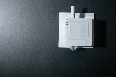 Device for controlling a smart home in socket. IOT control device. Server for smart home control. WIFI server to control IOT. Device for a smart home on a gray wall background. Installing IOT systemの写真素材
