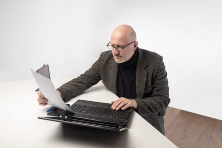 Office worker with laptop. Portrait of an office worker sitting at the table. An adult man in a...