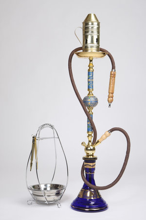 Oriental hookah on a light background. Hookah with a metal bowl for coal. Hookah smoking. Calabash...