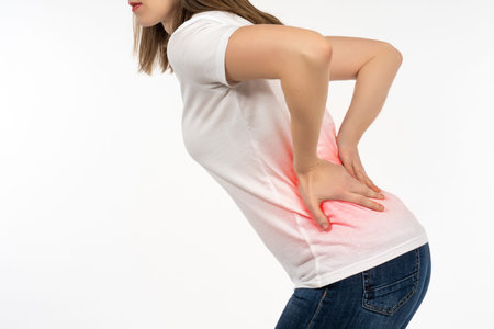 Back pain. Girl is tormented by problems in loins. Woman hold on lower back. Concept girl needs...
