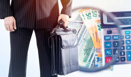 Assets concept. A businessman with a briefcase on the background of bills. Portfolio of assets. Business, entrepreneurship, investment. Financial analysis. The company's budget and personal budget.の写真素材