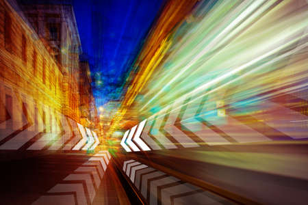 Traffic night lights. Effect speed of movement in cityscapes. White arrows on background traffic night lights. Colorful light trails with motion effect. Traffic night exposure or slow shutter pictureの写真素材