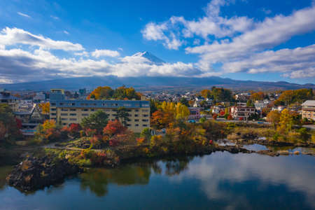 Fujiyama in Japan. Lake Kawaguchiko in autumn. Autumn landscape of Fujikawaguchiko city. Mount Fuji is visible behind the clouds. A bird's eye view of Japan city. Travel to Mount Fujiyama.の写真素材