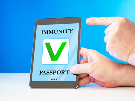 Covid 19 vaccination certificat in e-tablet. Man shows immunity passport during coronavirus...