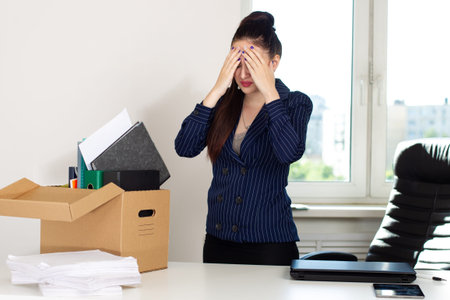 Girl is upset by dismissal. Woman lost her job. Fired manager in company. Dismissal box stands on...