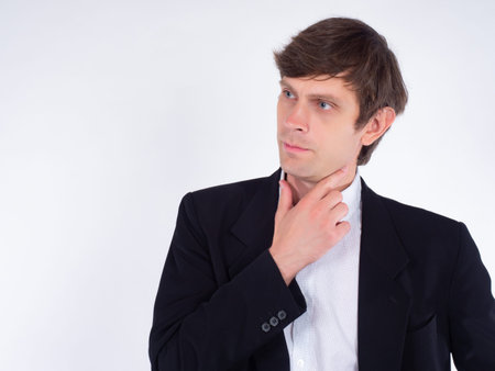 Man on a white background with a pensive look. Portrait of a man in a business suit. Pensive...