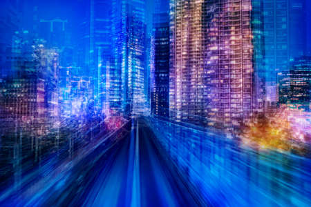 Car road in night city. Speed effect next to auto-track. Evening city with skyscrapers. Concept - fast movement around city. High-speed movement in the metropolis. Evening metropolis.の写真素材