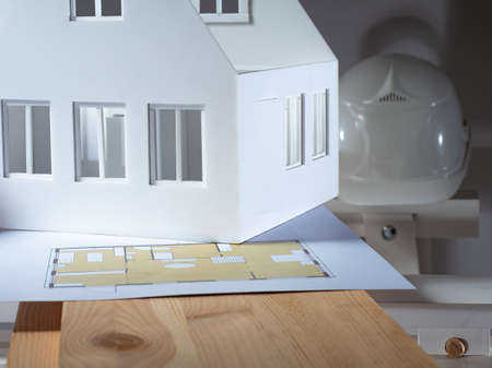 Architectural or building concept. Personal belongings of architect. Architectural drawings on a wooden board. Construction drawings next to white hard hat. Concept - construction services.の写真素材
