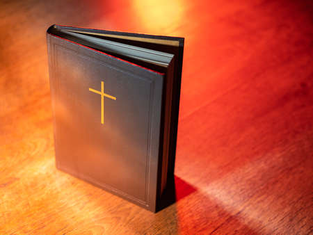 Holy Bible close up. Bible on a wooden table. Book with cross of Christian religion. Concept of studying Christian religion by Bible. Belief in Catholicism or Orthodoxy. Catholic prayer bookの写真素材