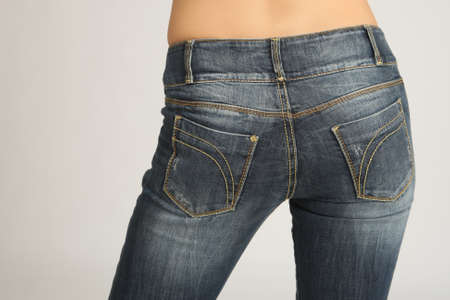 Back view of the girl's hips in jeans. Woman in gray denim pants. Close-up of a female butt in jeans. girls butt in casual pants. Woman in tight denim pants. Concept - sale of denim clothesの写真素材