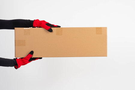 Delivery of goods. The courier is holding a long box with a place for the text. Online shopping and...