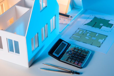 Calculator and architectural drawings on table. Personal belongings of architect. Compass and construction drawings as design symbol. Design of residential buildings. Creation architectural projectsの写真素材
