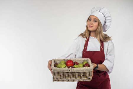Healthy food. Healthy lifestyle concept. Fruit in the hands of the cook. Girl is holding a fruit basket. Vitamins in food. Sale of fresh fruit. Fruit deliveries. Isolated on white. Space for the textの写真素材