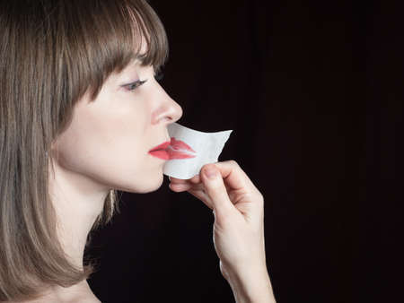 Decision start talking concept. Violation of women rights. Woman taking tape off her mouth symbolizes feminism. Feministaka pastes tape from her lips. Girl face on black background. Feminism protestの写真素材