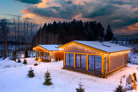 Village houses in winter weather. Two houses with panoramic windows in nature. Cottages next to forest. Country cottages at dawn. Country houses near winter taiga. Summer cottages covered with snowのeditorial素材