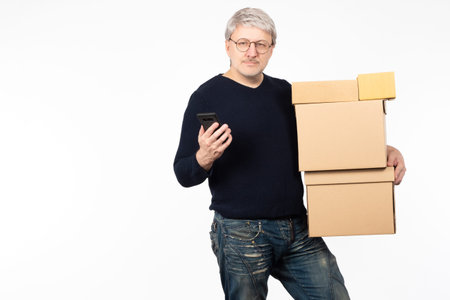 Online store owner. Small business owner. A man with a smartphone and cardboard boxes. The manager...