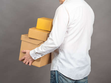 Delivery man holding cardboard boxes. Fast and free Delivery transport. Online shopping and Express delivery. Postal service. Parcel service. Courier with parcels.の写真素材