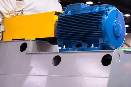 Blue industrial electric motor. Agricultural electric motor on a gray metal box. Concept - sale of industrial motors. Agricultural equipment. Electric motor for air conditioning or heating system.の写真素材