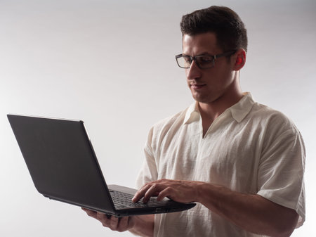 man laptop with glasses. Computer master on light background. Focused Computer master with laptop....