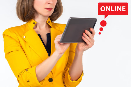 Woman uses internet. Businesswoman with tablet. Girl in yellow jacket. Portrait of businesswoman on...