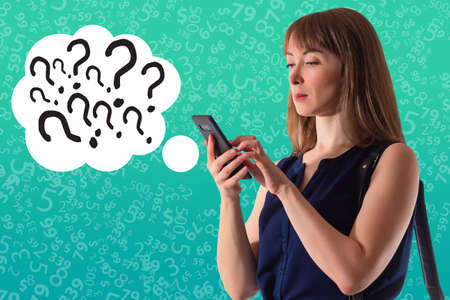 Question marks near woman. Woman is thinking about something. Businesswoman has questions. Woman asks questions in a smartphone. Girl on green background. Girl asks in apps. Applications for asksの写真素材