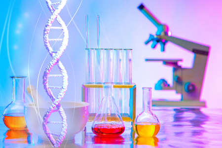 Ginetic laboratory work table. Microscope and medical test tubes are on table. DNA strand as a symbol of the science of genetics. Ginetic Engineering. Working with DNA modification. DNA sequencingの写真素材