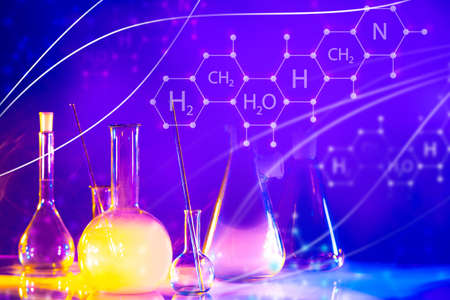 Laboratory glassware next to chemical elements. Chemical laboratory glassware with multi-colored liquid. Logos with chemical elements on a violet background. Test tubes in chemist laboratoryの写真素材