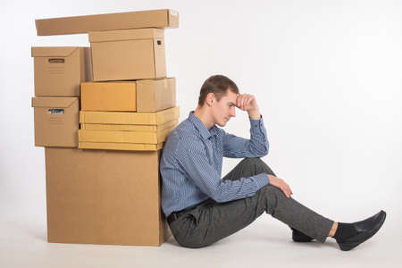 Business failure. Businessman ruin. Sad man is sitting next to cardboard boxes. Entrepreneur feel stressful depressed situation. Unemployed jobless people. Economic crisis. Business losses.の写真素材