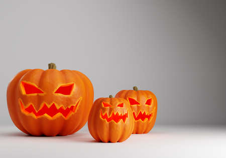 Halloween pumpkin in different sizes. Three Halloween pumpkin on a gray background. Pumpkin in form of jack o'lantern. gourds with scary faces. Hallows' eve party preparation concept. 3d imageの写真素材
